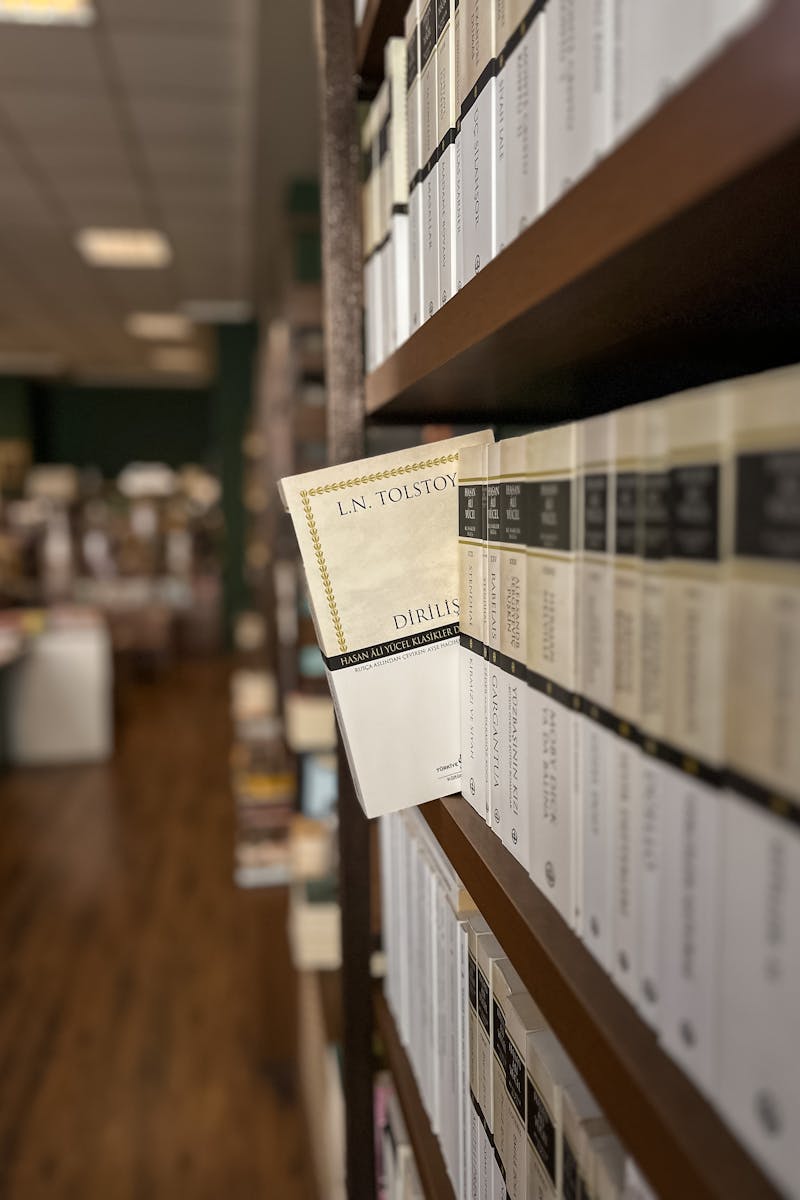 A focused shot of a library bookshelf featuring Tolstoy's book, displaying a rich literary atmosphere.